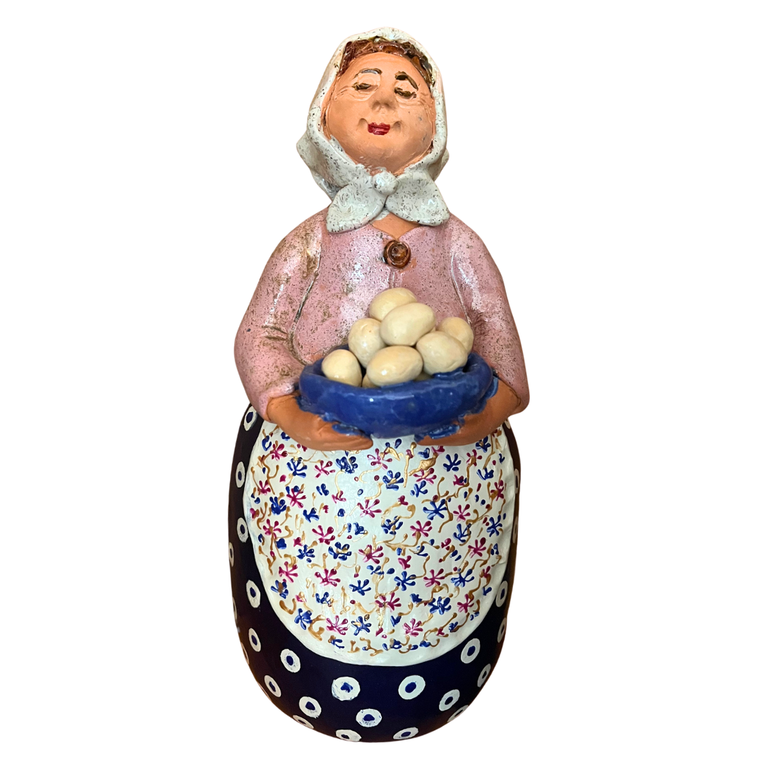 Hand-painted folk art babcia grannie figurine holding a bowl of fresh eggs