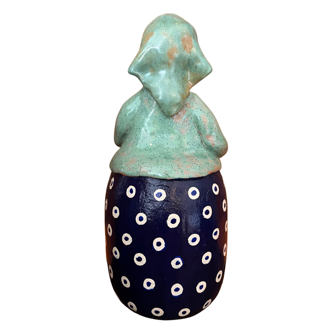 Charming hand-painted “Babcia Holding a Book” figurine featuring a Polish grandmother in an aqua scarf and floral apron. A heartwarming gift and beautiful piece of folk-inspired home décor.