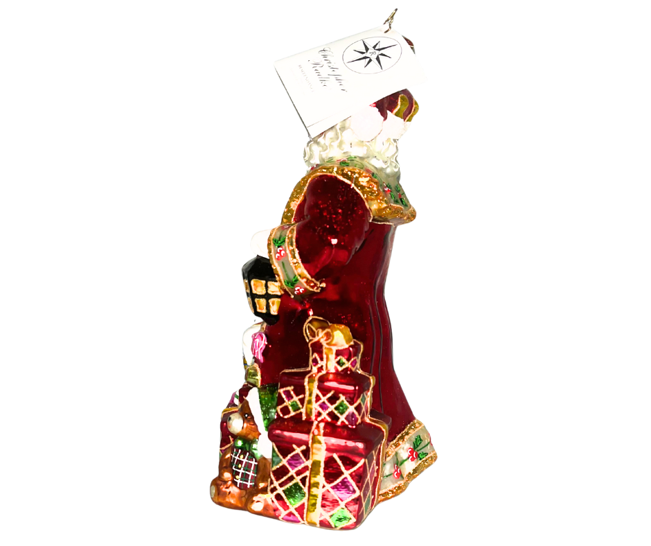 Luxurious Santa with lantern, tree, and toys at his feet. Handcrafted, hand-painted Christopher Radko glass ornament made in Poland — a radiant holiday centerpiece.