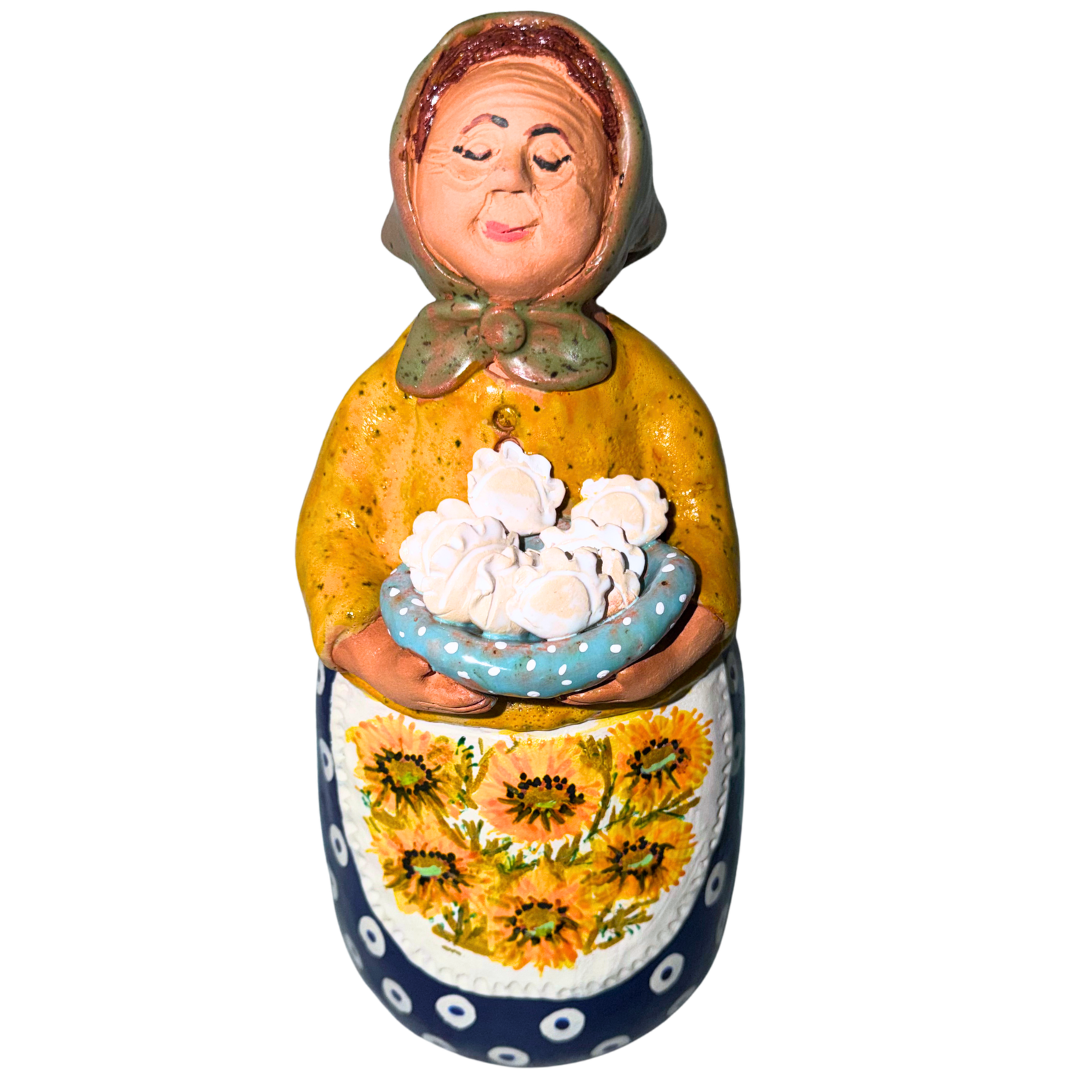 Hand-painted handcrafted babcia figurine holding a bowl of pierogi.