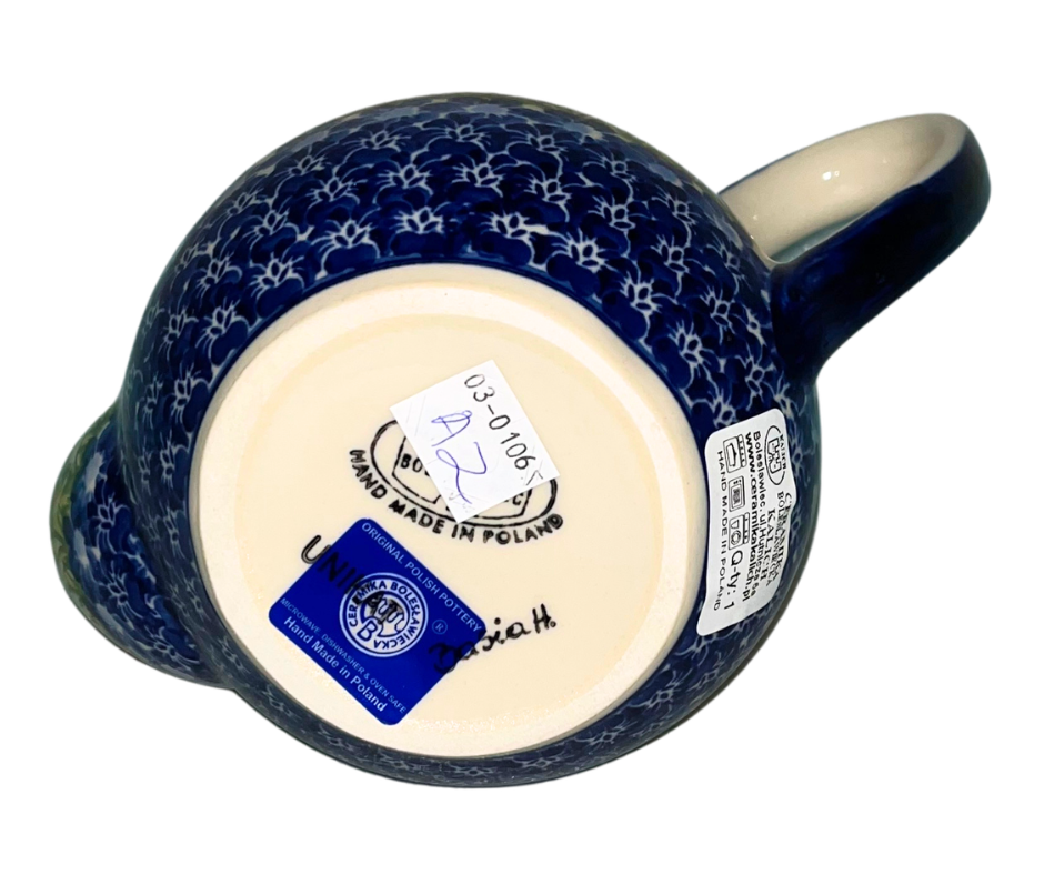 Kalich Polish Pottery floral pattern with red and yellow blossoms, white accents, and green foliage on cream with cobalt rim; hand-painted meadow design with light, airy composition