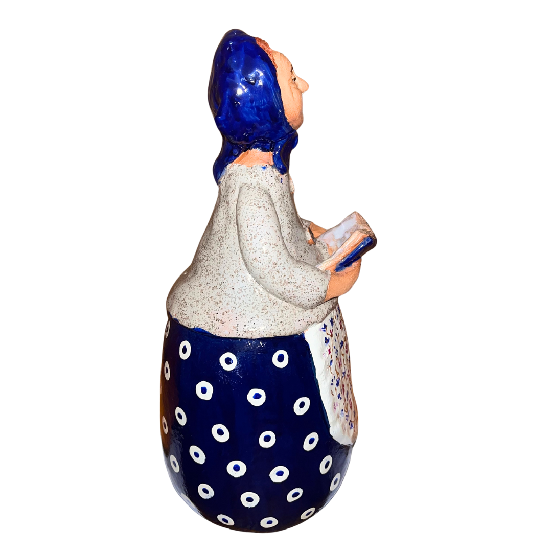 Charming hand-painted “Babcia Holding a Book” figurine featuring a Polish grandmother in an aqua scarf and floral apron. A heartwarming gift and beautiful piece of folk-inspired home décor.