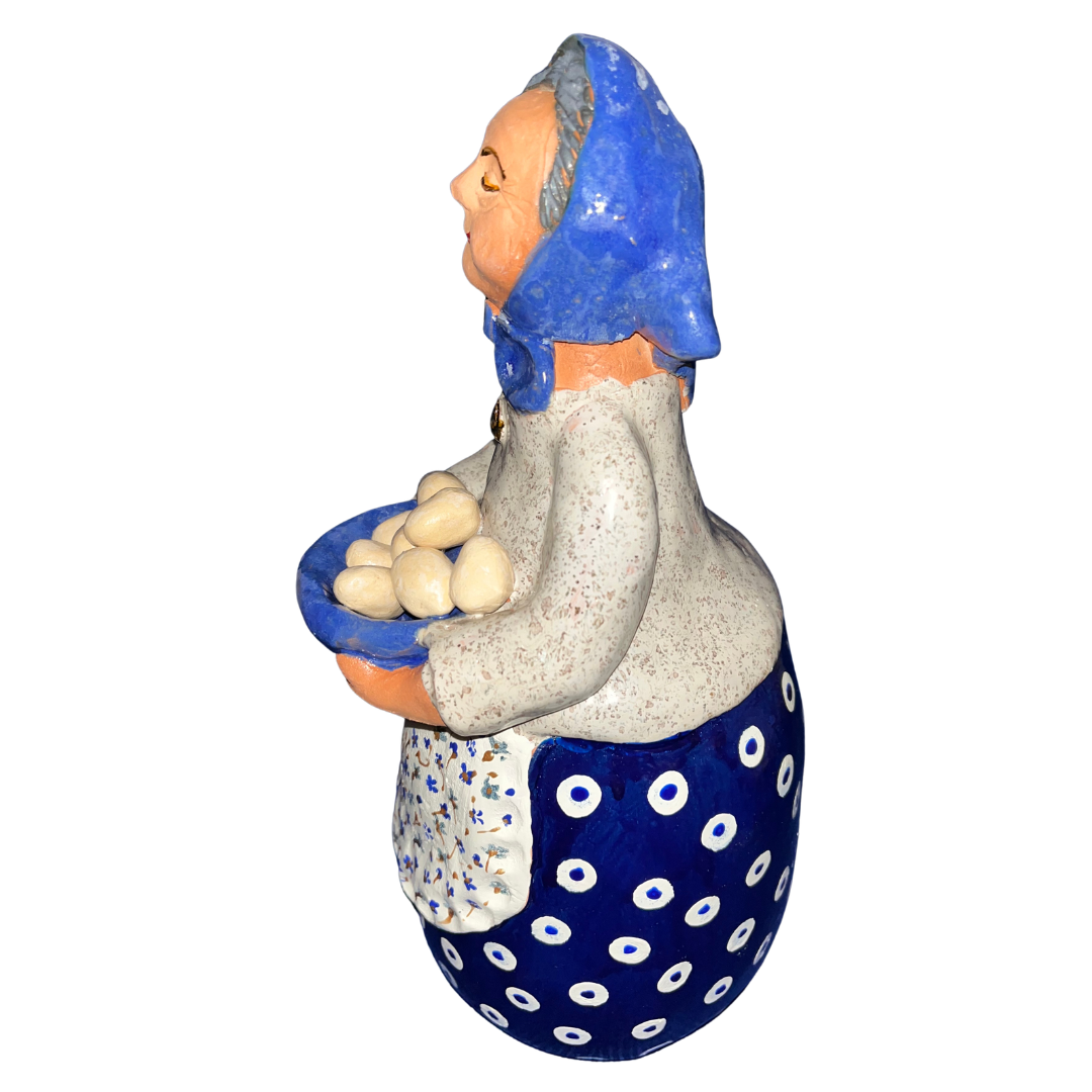 Hand-painted folk art babcia grannie figurine holding a bowl of fresh eggs