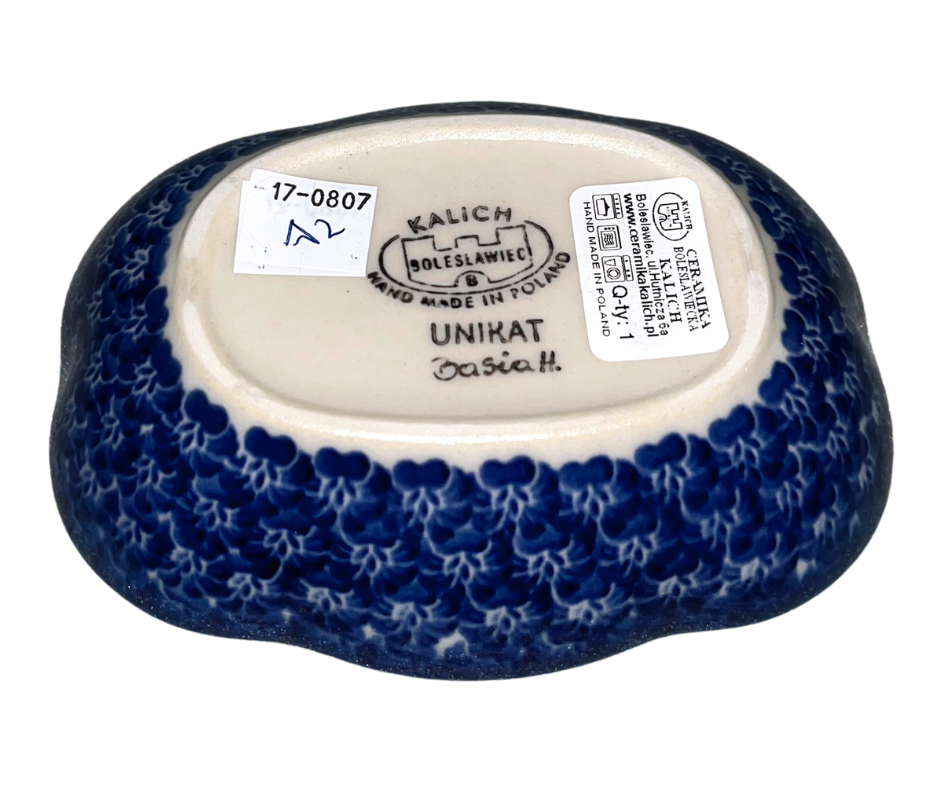 Kalich Polish Pottery floral pattern with red and yellow blossoms, white accents, and green foliage on cream with cobalt rim; hand-painted meadow design with light, airy composition.