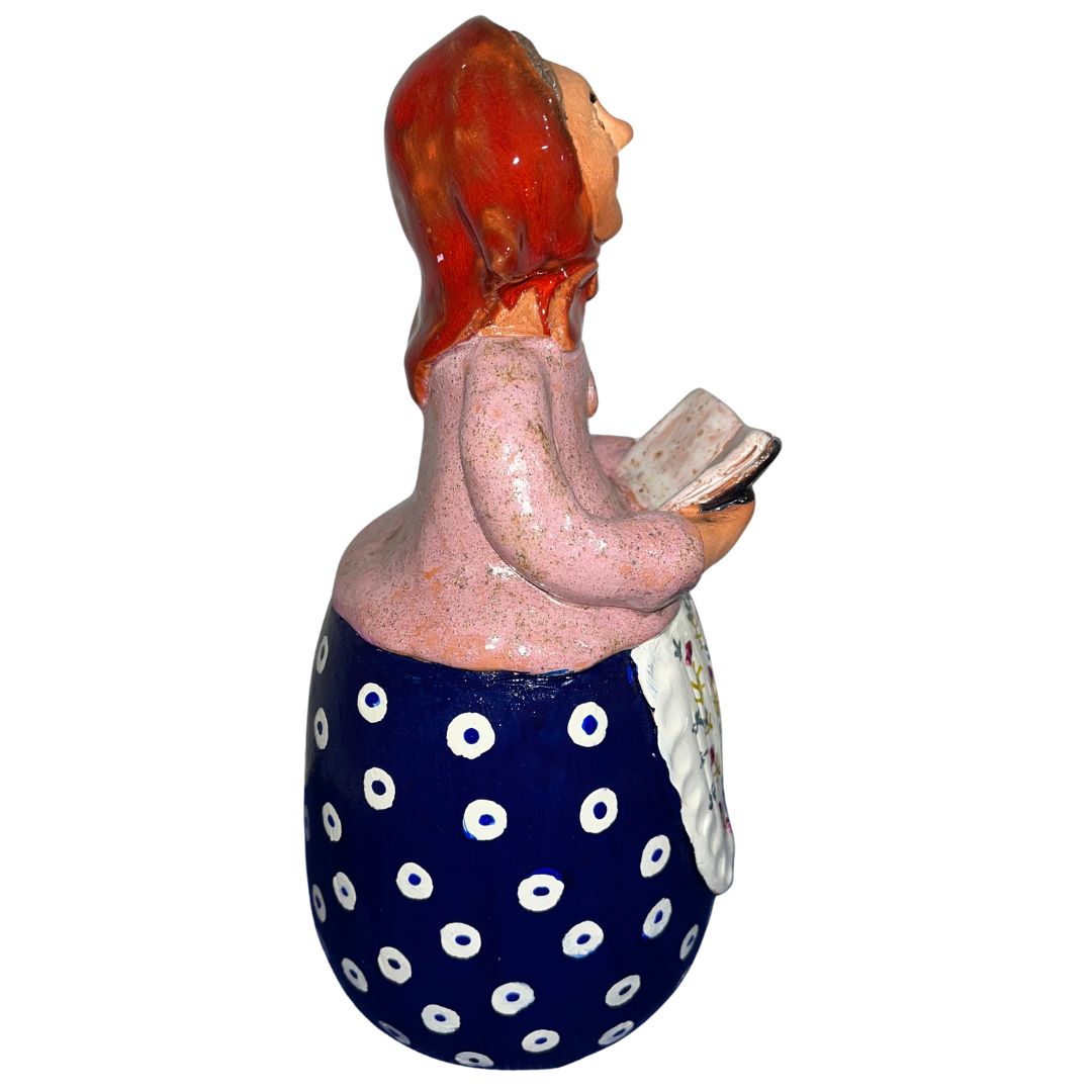 Charming hand-painted “Babcia Holding a Book” figurine featuring a Polish grandmother in an aqua scarf and floral apron. A heartwarming gift and beautiful piece of folk-inspired home décor.