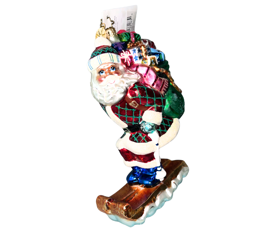 Santa races downhill on a glittering sled with a sack full of gifts. Handcrafted, hand-painted Christopher Radko glass ornament made in Poland.