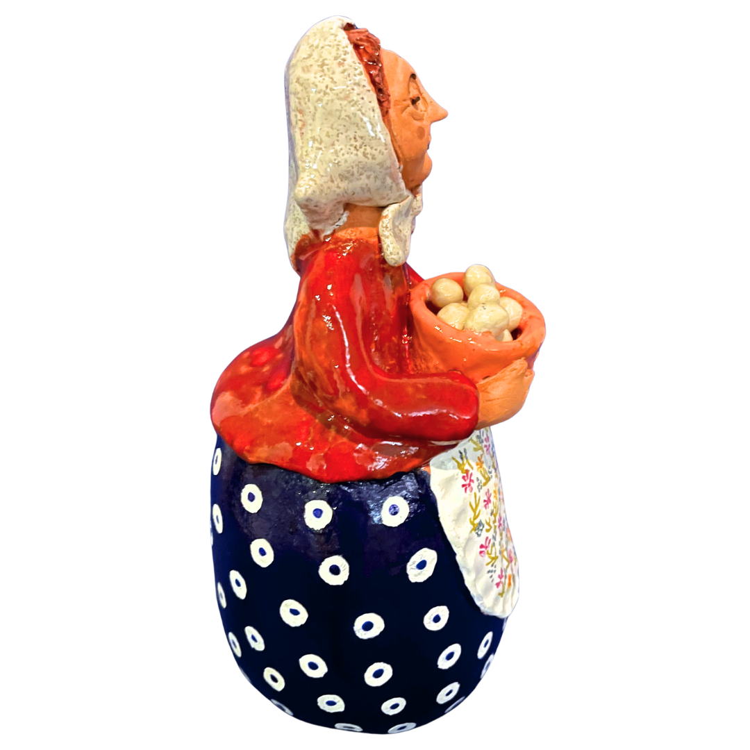 Hand-painted folk art babcia grannie figurine holding a bowl of fresh eggs