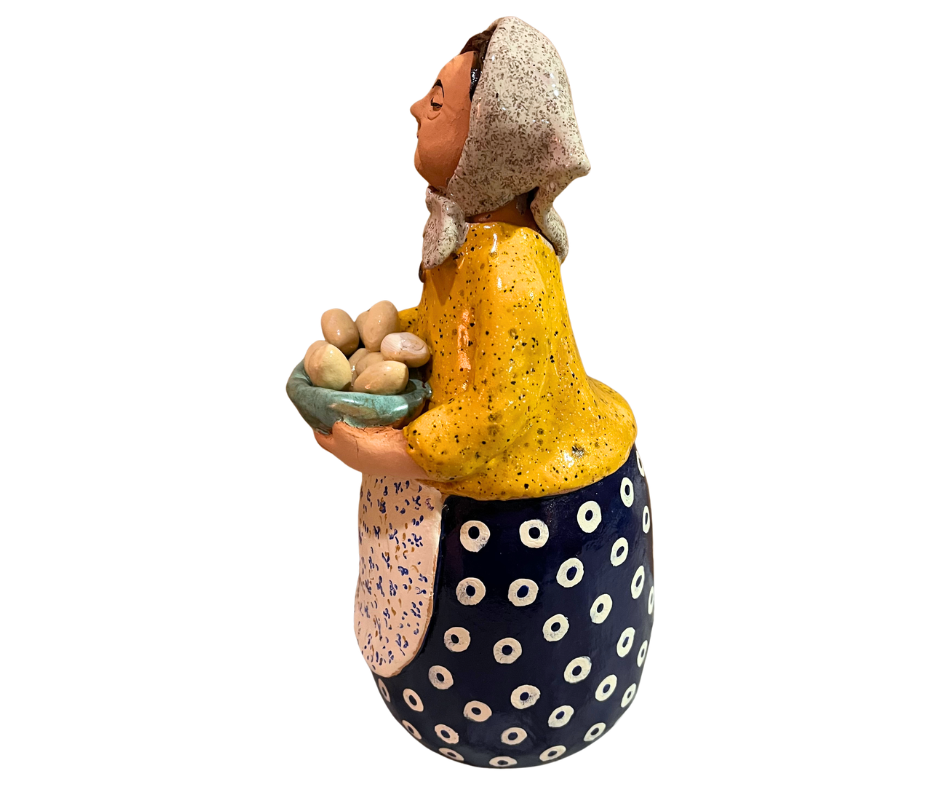 Hand-painted babcia grannie figurine holding a bowl of fresh eggs, wearing a tan scarf and floral apron