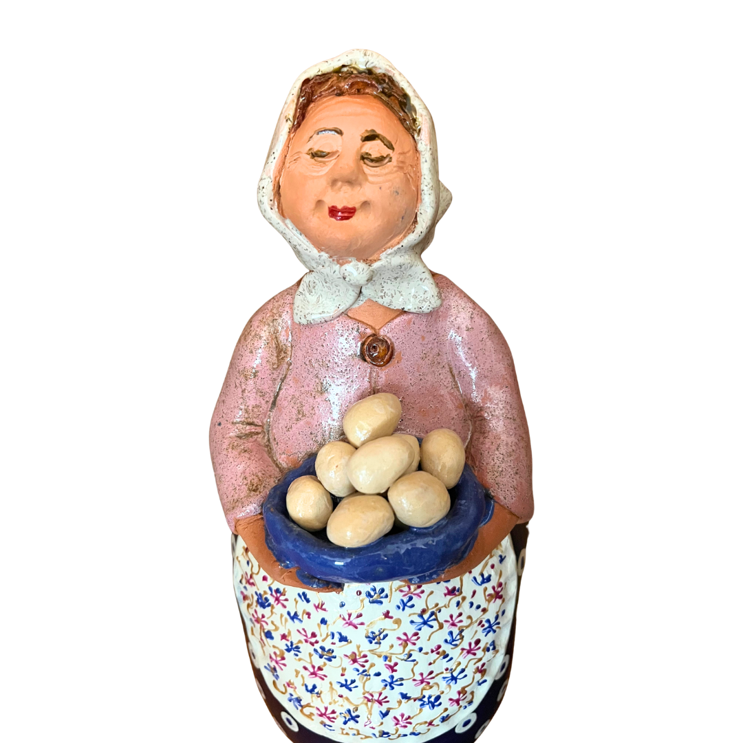 Hand-painted folk art babcia grannie figurine holding a bowl of fresh eggs