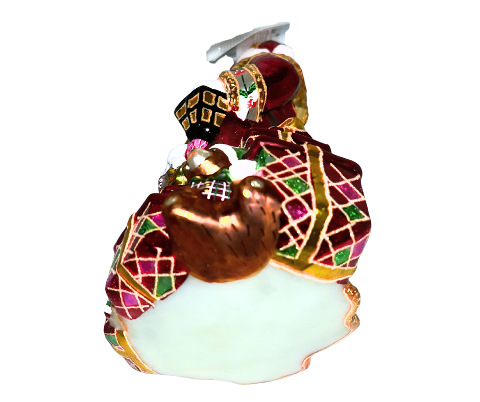 Luxurious Santa with lantern, tree, and toys at his feet. Handcrafted, hand-painted Christopher Radko glass ornament made in Poland — a radiant holiday centerpiece.