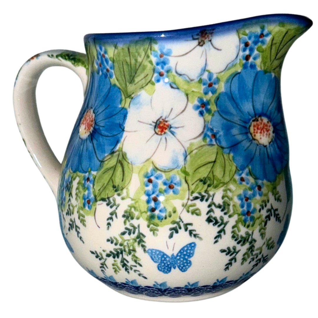 Ceramika Kalich Polish Pottery 24 oz Kubus pitcher with blue and white flowers, green foliage and butterflies, handcrafted in Bolesławiec, Poland.