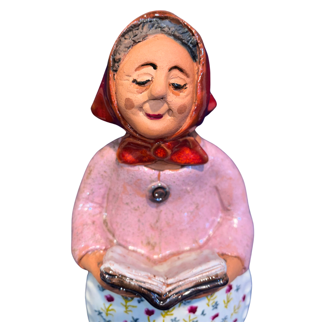 Charming hand-painted “Babcia Holding a Book” figurine featuring a Polish grandmother in an aqua scarf and floral apron. A heartwarming gift and beautiful piece of folk-inspired home décor.