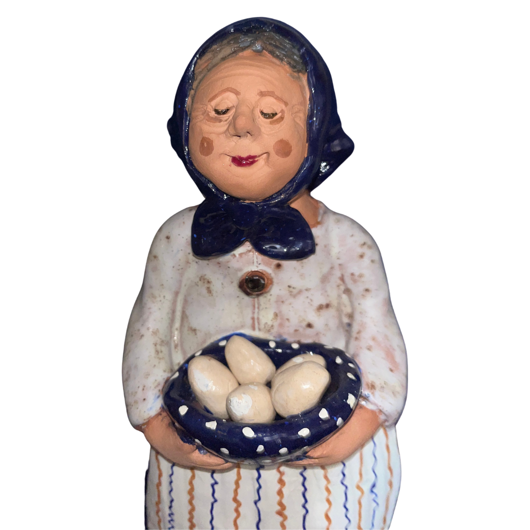 Hand-painted folk art babcia grannie figurine holding a bowl of fresh eggs