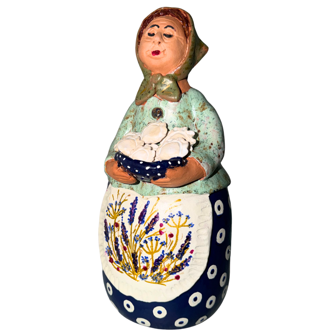 Hand-painted handcrafted babcia figurine holding a bowl of pierogi.