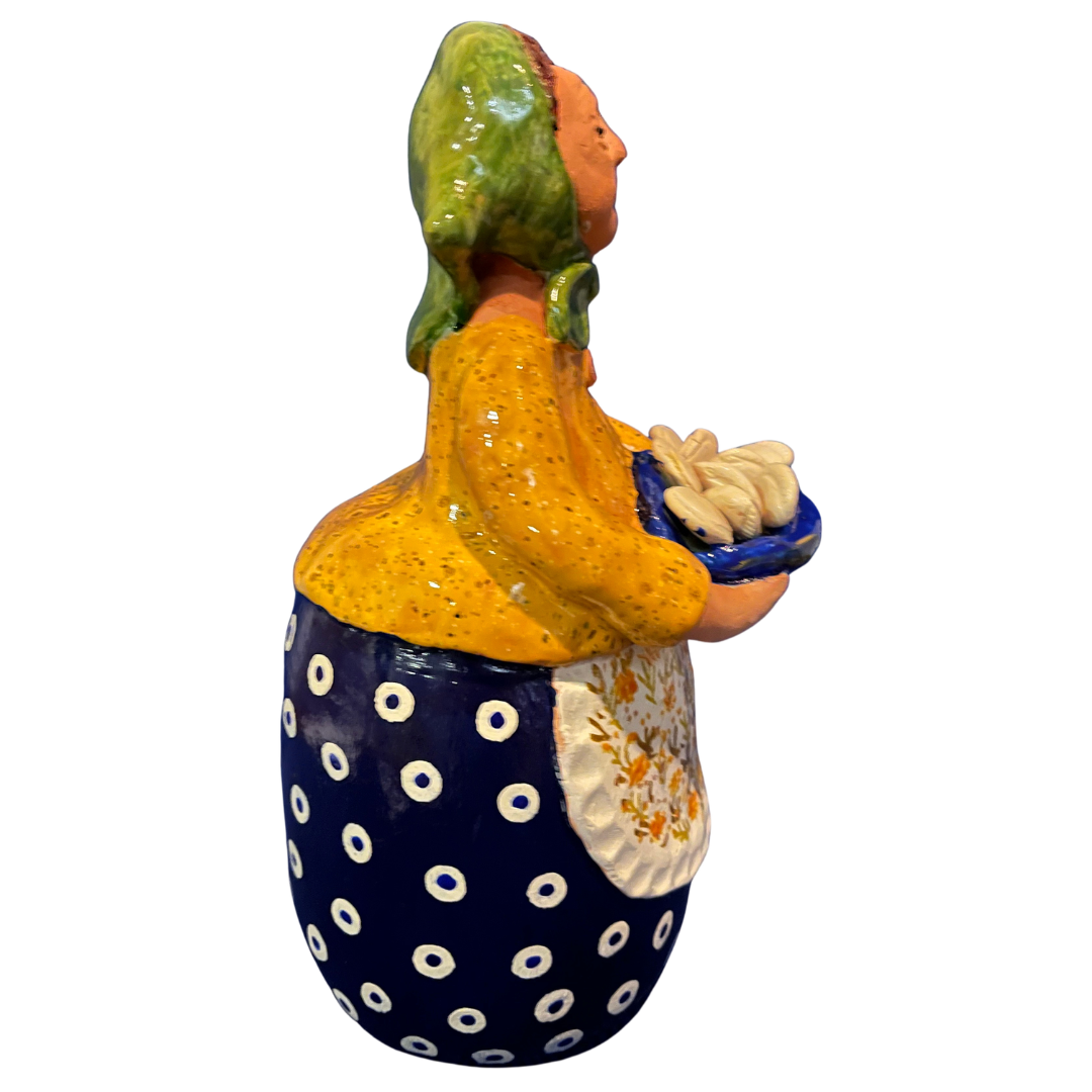 Hand-painted handcrafted babcia figurine holding a bowl of pierogi.