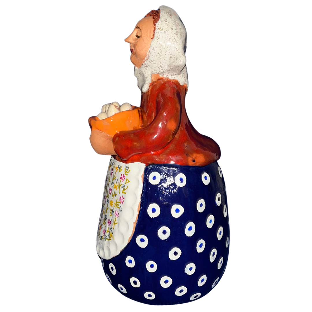 Hand-painted folk art babcia grannie figurine holding a bowl of fresh eggs