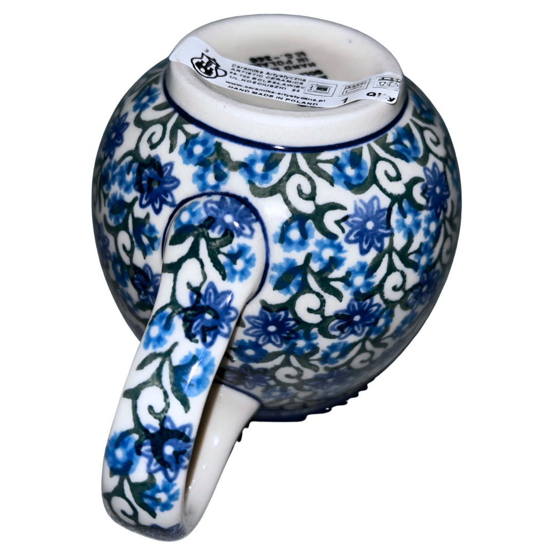 Ceramika Artystyczna Pattern 1459X Daisy Lace features blue daisy blossoms, scrolling green vines, and a cobalt rim. Handcrafted Polish pottery from Bolesławiec, Poland.