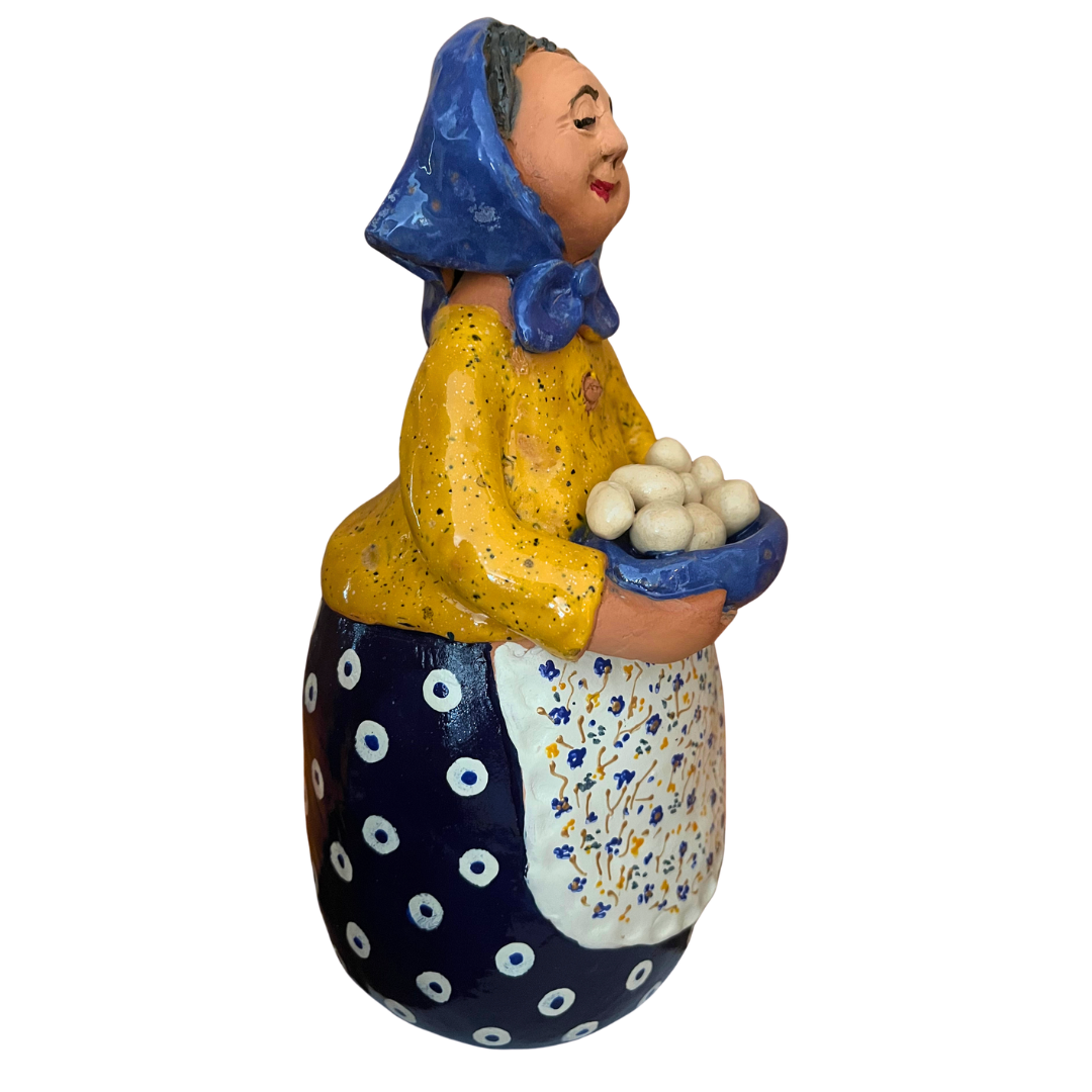 Hand-painted folk art babcia grannie figurine holding a bowl of fresh eggs