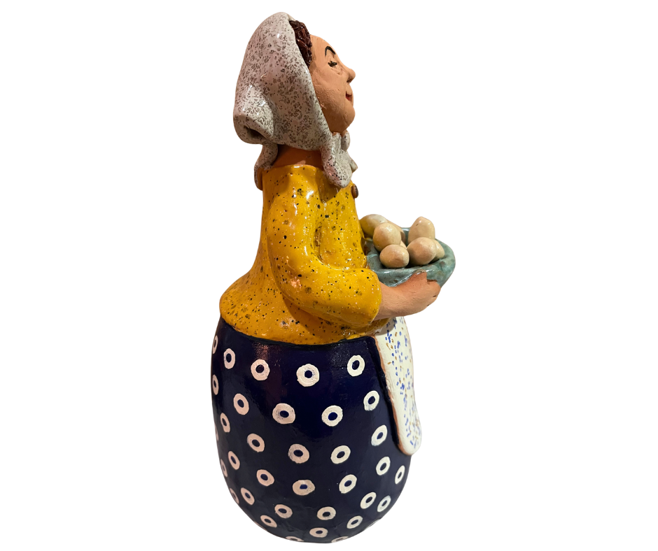 Hand-painted babcia grannie figurine holding a bowl of fresh eggs, wearing a tan scarf and floral apron