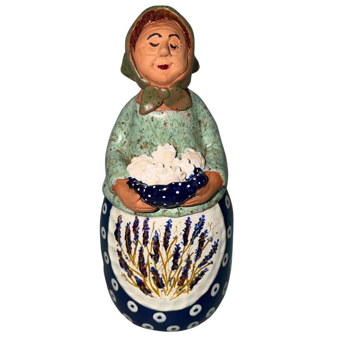 Hand-painted handcrafted babcia figurine holding a bowl of pierogi.