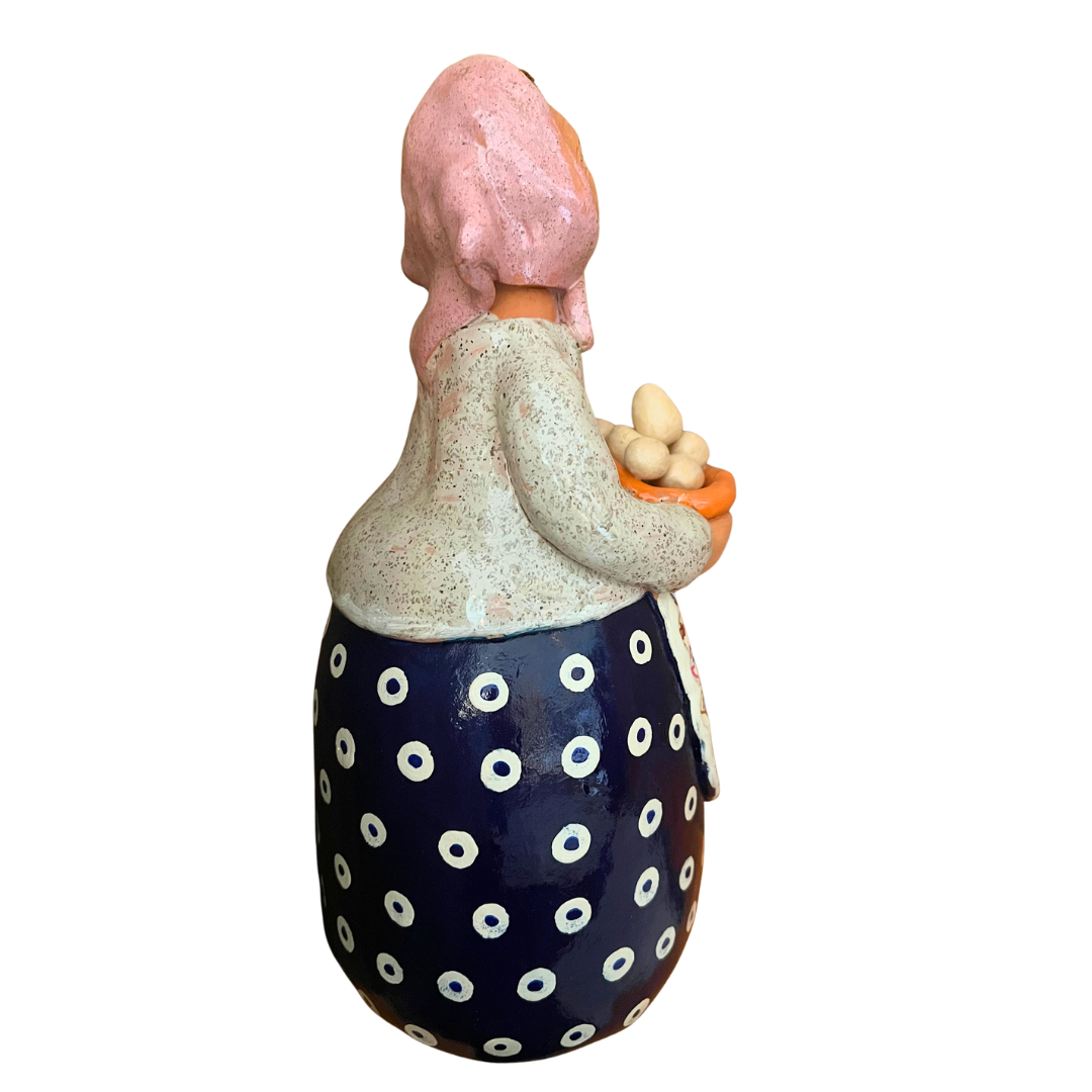 Hand-painted folk art babcia grannie figurine holding a bowl of fresh eggs