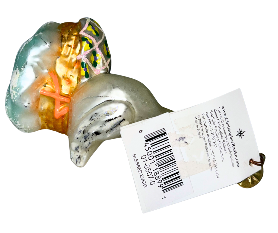 Vintage Christopher Radko “Blessed Event” glass ornament featuring a stork carrying a baby. Handcrafted European collectible celebrating new life and parenthood.