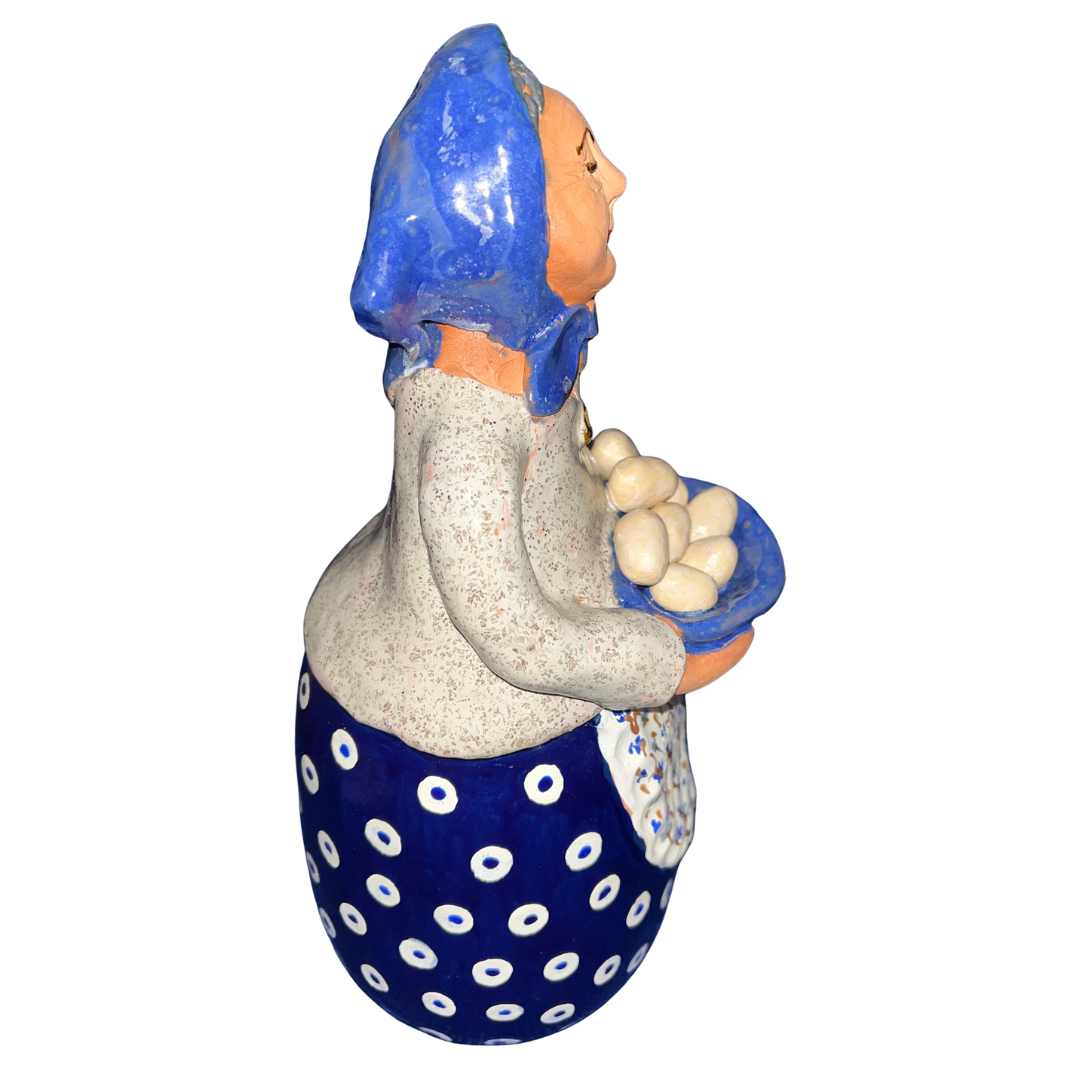 Hand-painted folk art babcia grannie figurine holding a bowl of fresh eggs