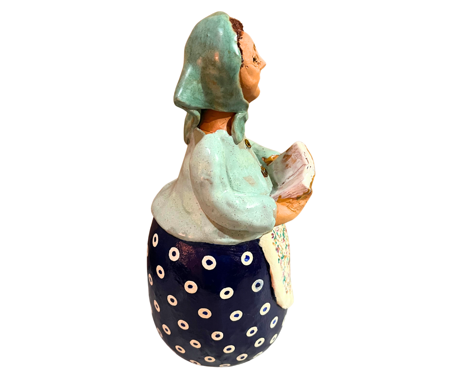 Charming hand-painted “Babcia Holding a Book” figurine featuring a Polish grandmother in an aqua scarf and floral apron. A heartwarming gift and beautiful piece of folk-inspired home décor.