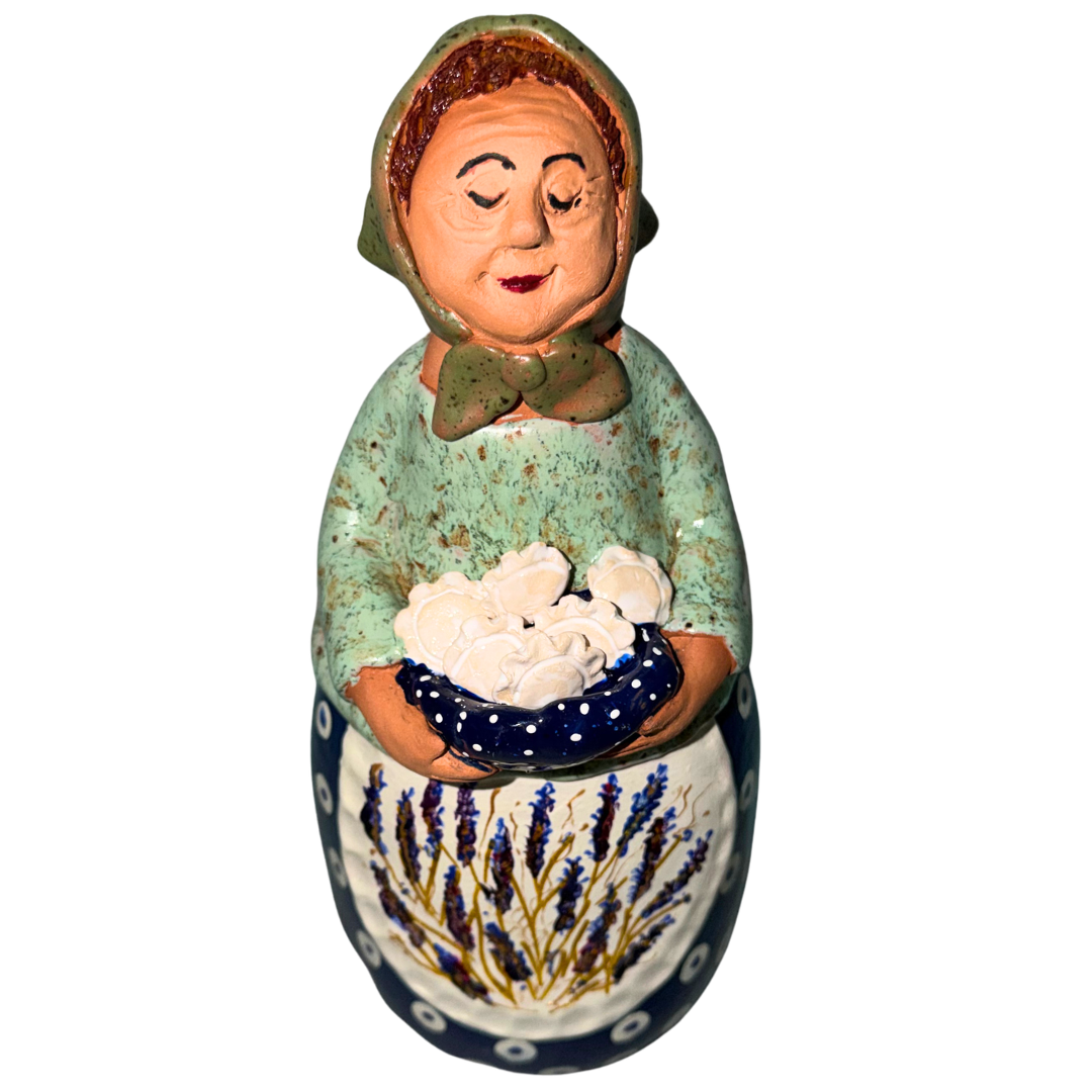 Hand-painted handcrafted babcia figurine holding a bowl of pierogi.