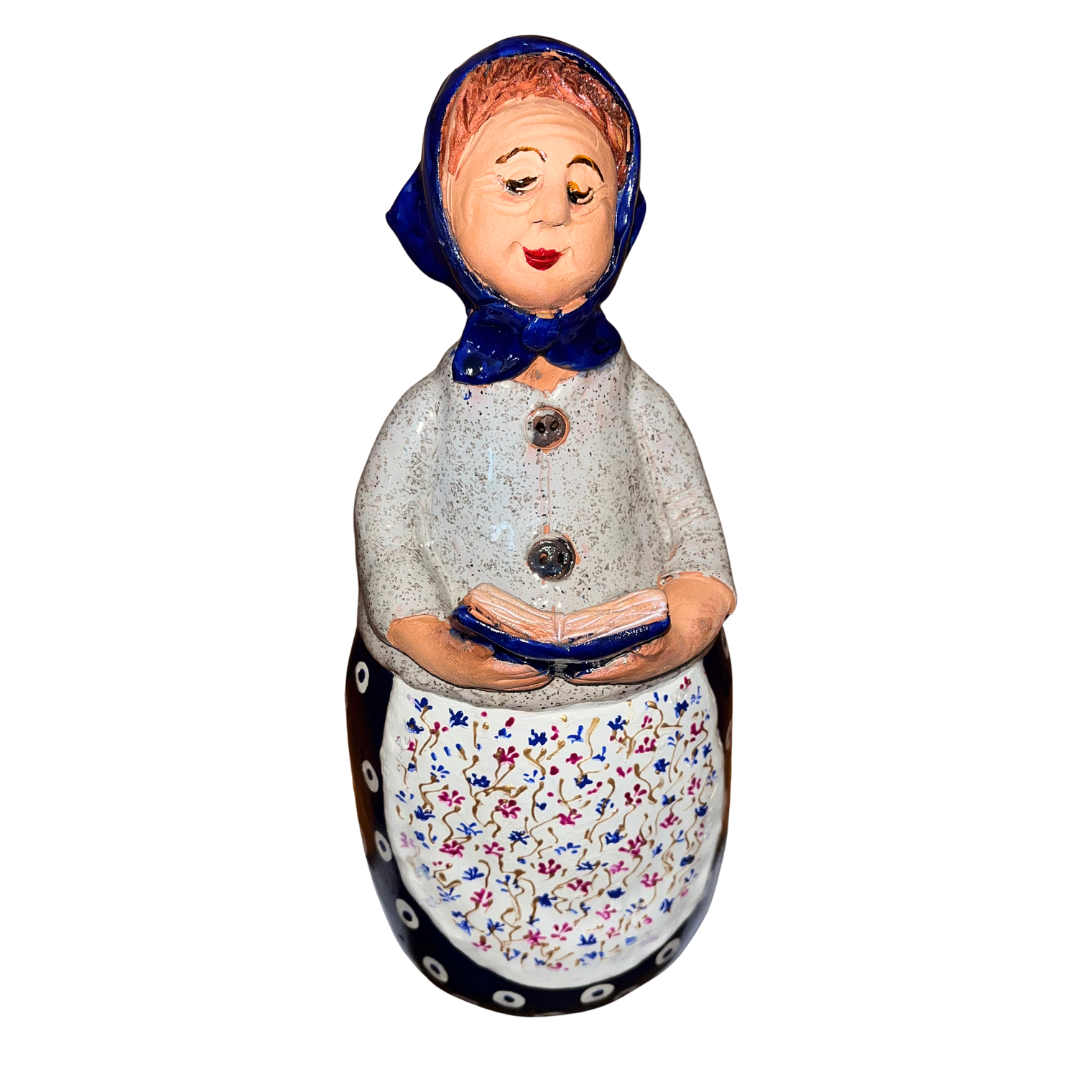 Charming hand-painted “Babcia Holding a Book” figurine featuring a Polish grandmother in an aqua scarf and floral apron. A heartwarming gift and beautiful piece of folk-inspired home décor.