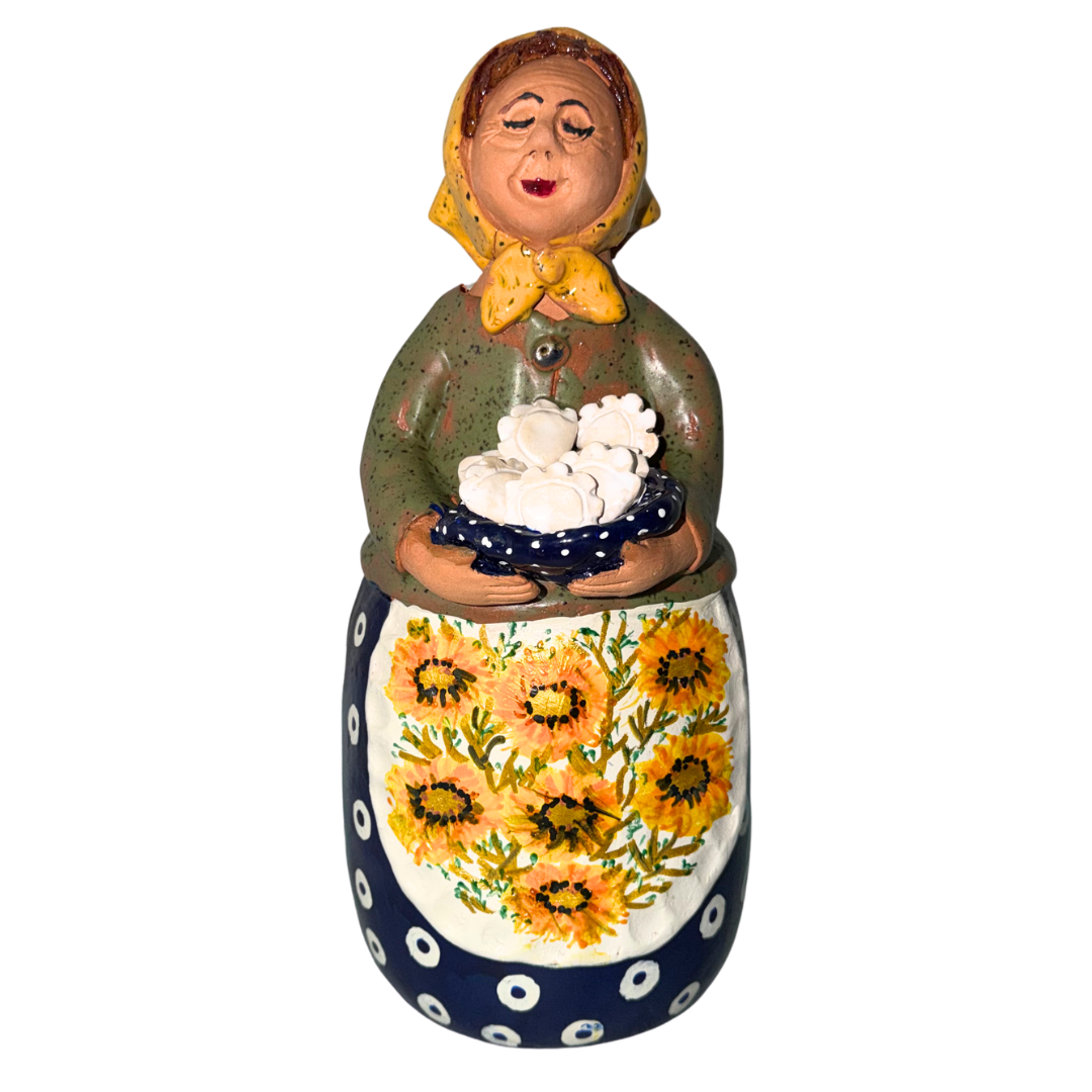 Hand-painted handcrafted babcia figurine holding a bowl of pierogi.