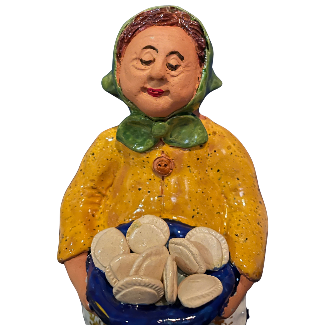 Hand-painted handcrafted babcia figurine holding a bowl of pierogi.