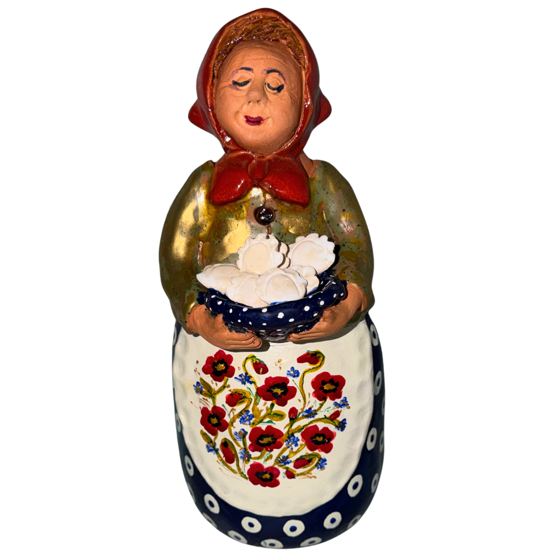 Hand-painted handcrafted babcia figurine holding a bowl of pierogi.