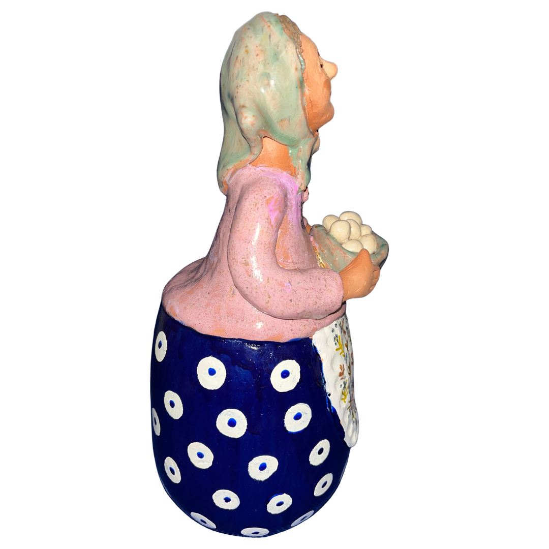Hand-painted folk art babcia grannie figurine holding a bowl of fresh eggs