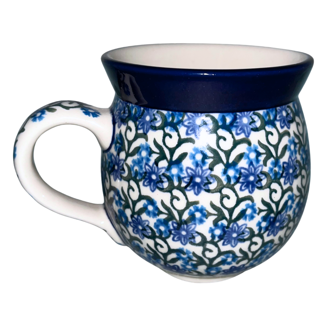 Ceramika Artystyczna Pattern 1459X Daisy Lace features blue daisy blossoms, scrolling green vines, and a cobalt rim. Handcrafted Polish pottery from Bolesławiec, Poland.