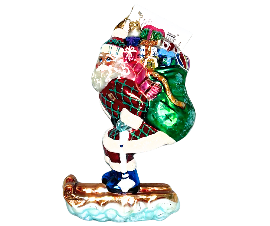 Santa races downhill on a glittering sled with a sack full of gifts. Handcrafted, hand-painted Christopher Radko glass ornament made in Poland.