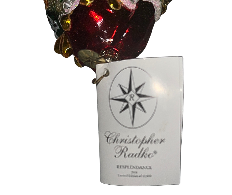 Luxurious Santa with lantern, tree, and toys at his feet. Handcrafted, hand-painted Christopher Radko glass ornament made in Poland — a radiant holiday centerpiece.