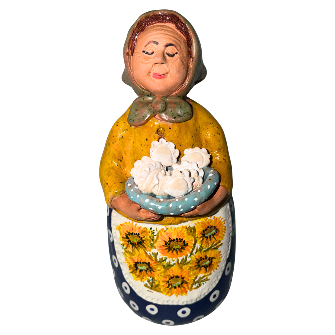 Hand-painted handcrafted babcia figurine holding a bowl of pierogi.