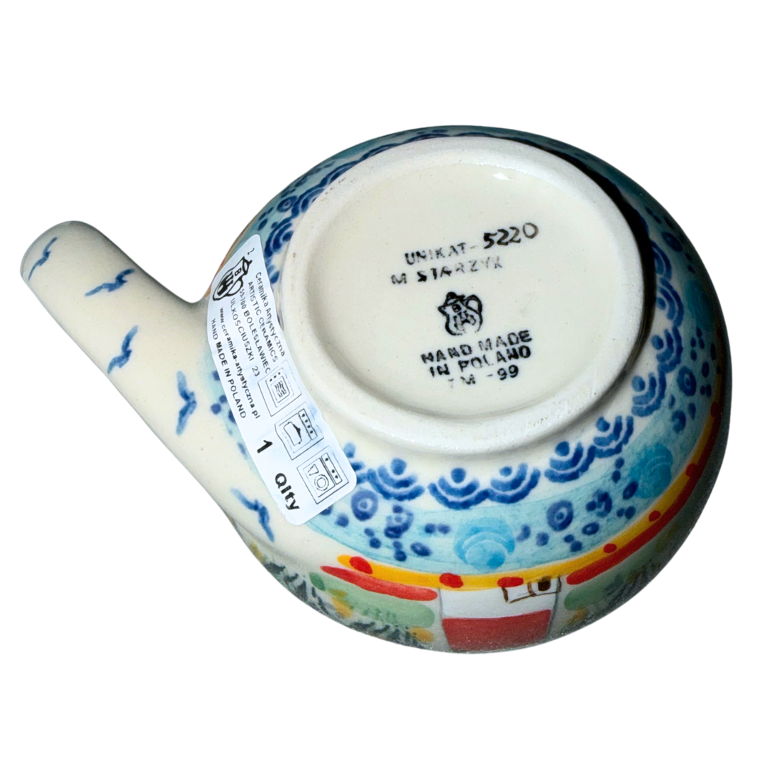 Ceramika Artystyczna U5220 Polish Pottery cat-shaped cup featuring a hand-painted lighthouse, coastal grasses and seabirds with a whimsical fish-tail handle.