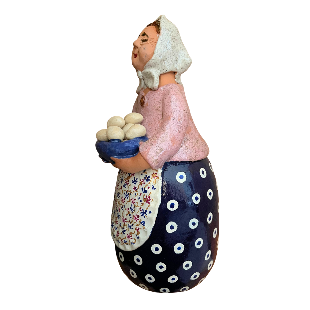 Hand-painted folk art babcia grannie figurine holding a bowl of fresh eggs