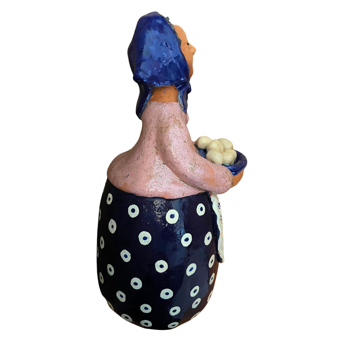 Hand-painted folk art babcia grannie figurine holding a bowl of fresh eggs