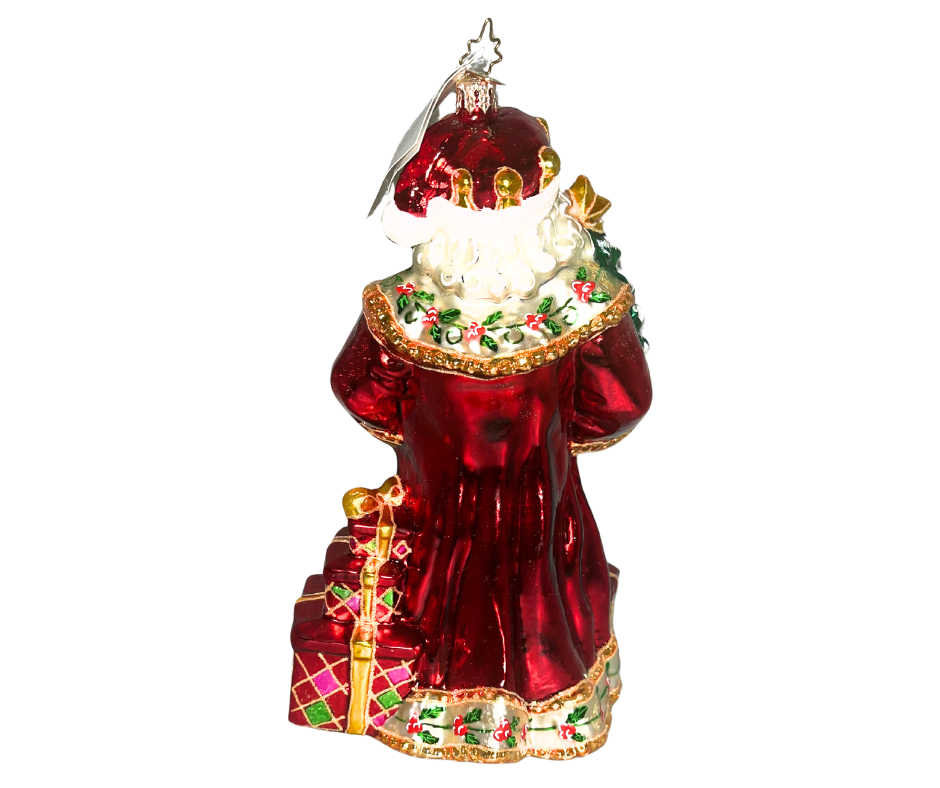 Luxurious Santa with lantern, tree, and toys at his feet. Handcrafted, hand-painted Christopher Radko glass ornament made in Poland — a radiant holiday centerpiece.