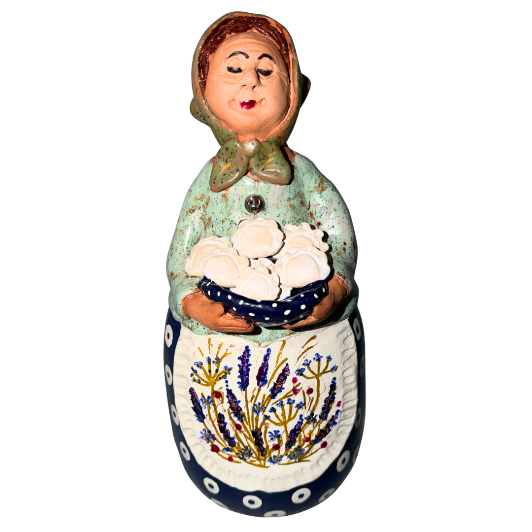 Hand-painted handcrafted babcia figurine holding a bowl of pierogi.