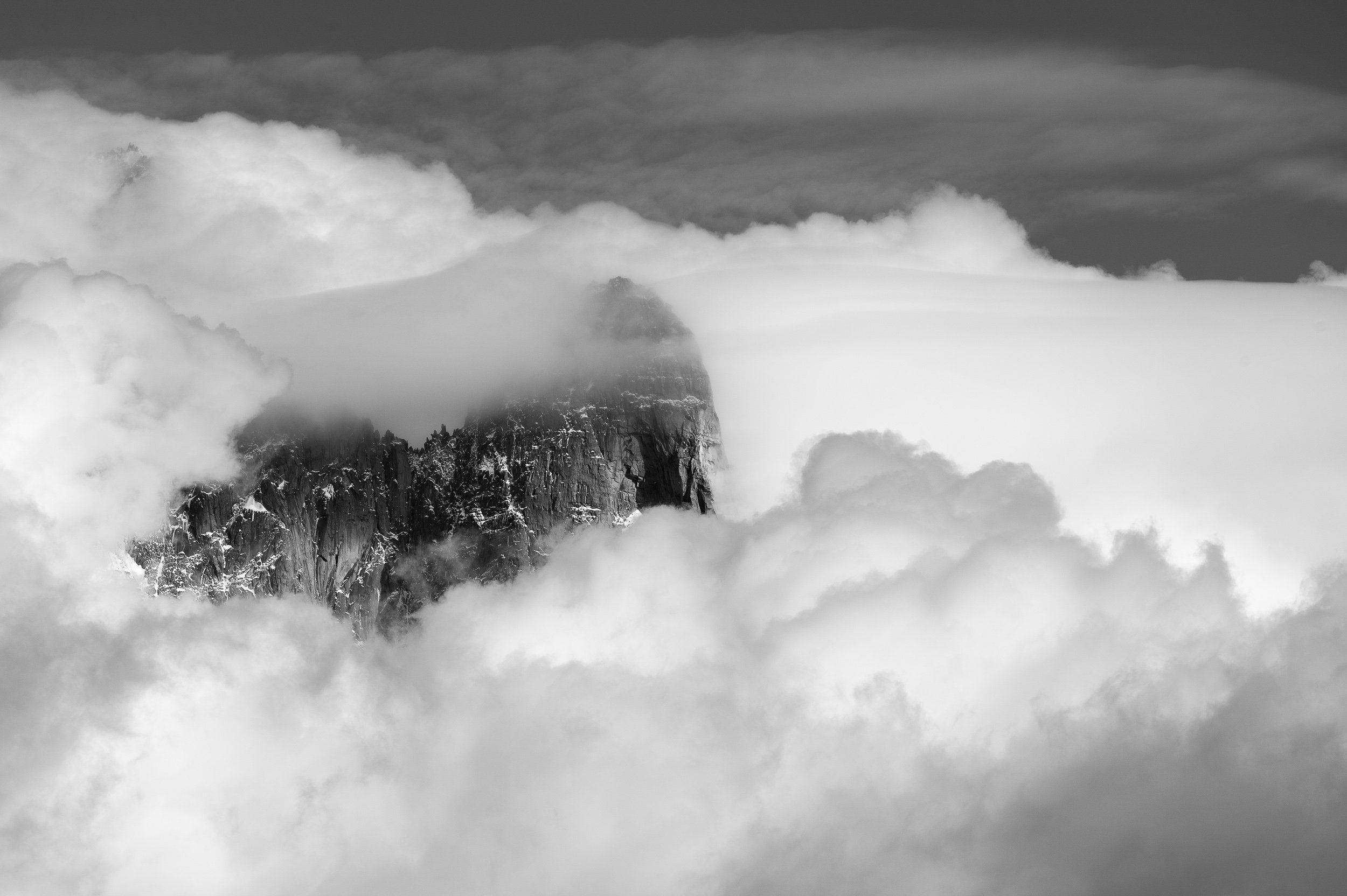 Aiguille du Dru summit peeks out of the clouds in the Chamonix region of France.