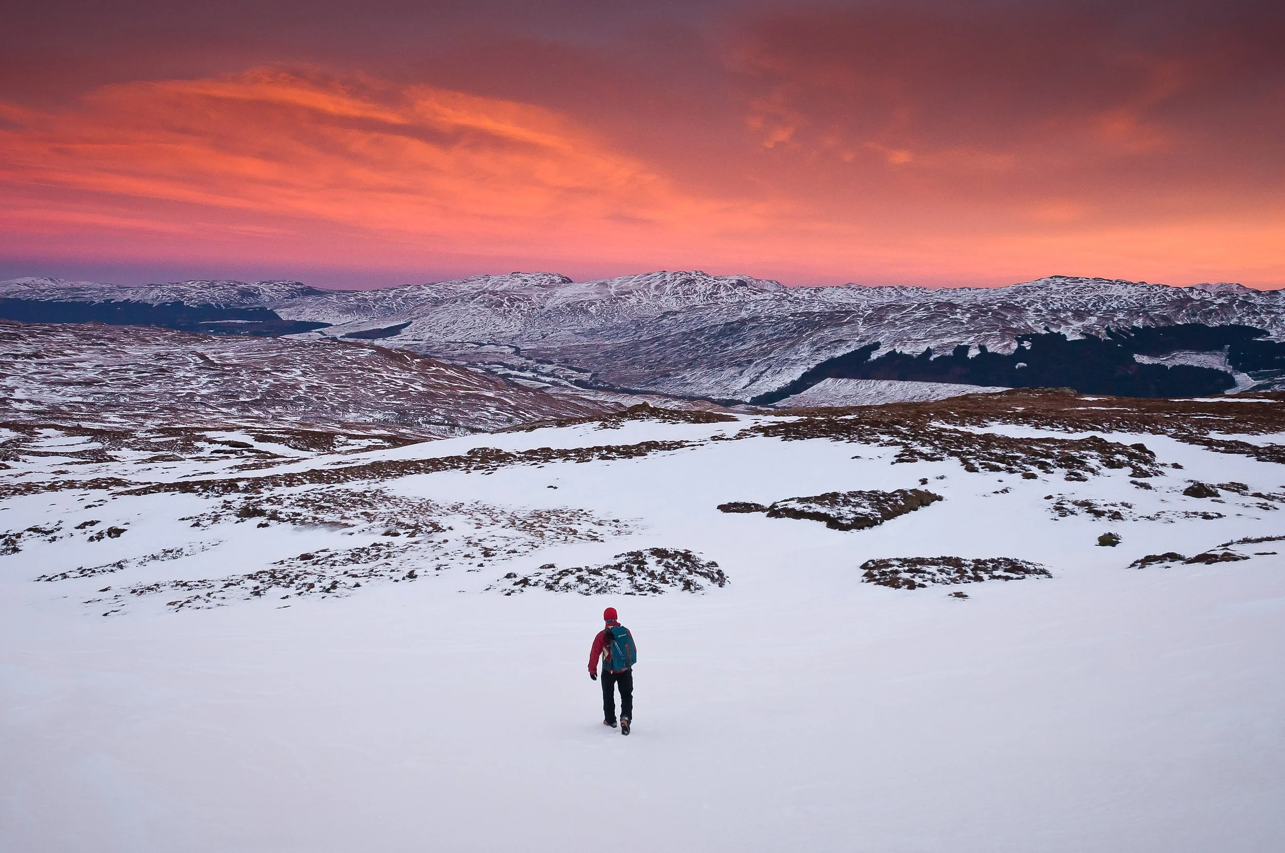 A colourful sunset as David Hetherington descends from Beinn Imirean, a Corbett near Crianlarich in the South-East Highlands of Scotland.