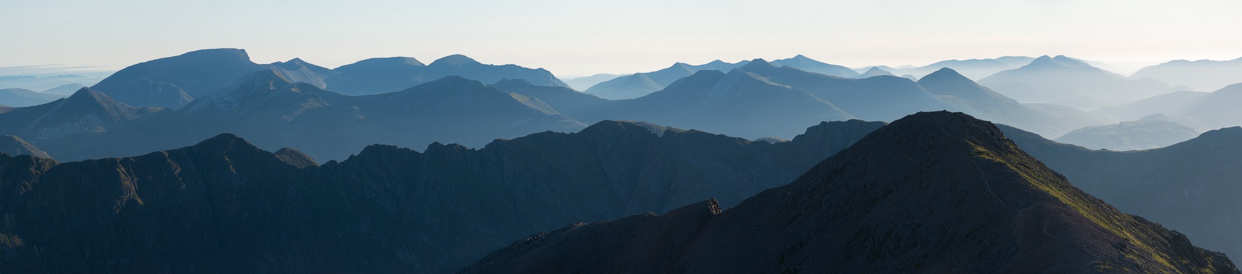 The panoramic view north from the summit of Bidean nam Bian, a Munro in Glen Coe in the West Highlands of Scotland, looking over Stob Coire nan Lochan, the Aonach Eagach plus most of the Mamores to Ben Nevis (the UK's highest peak), Carn Mor Dearg, A