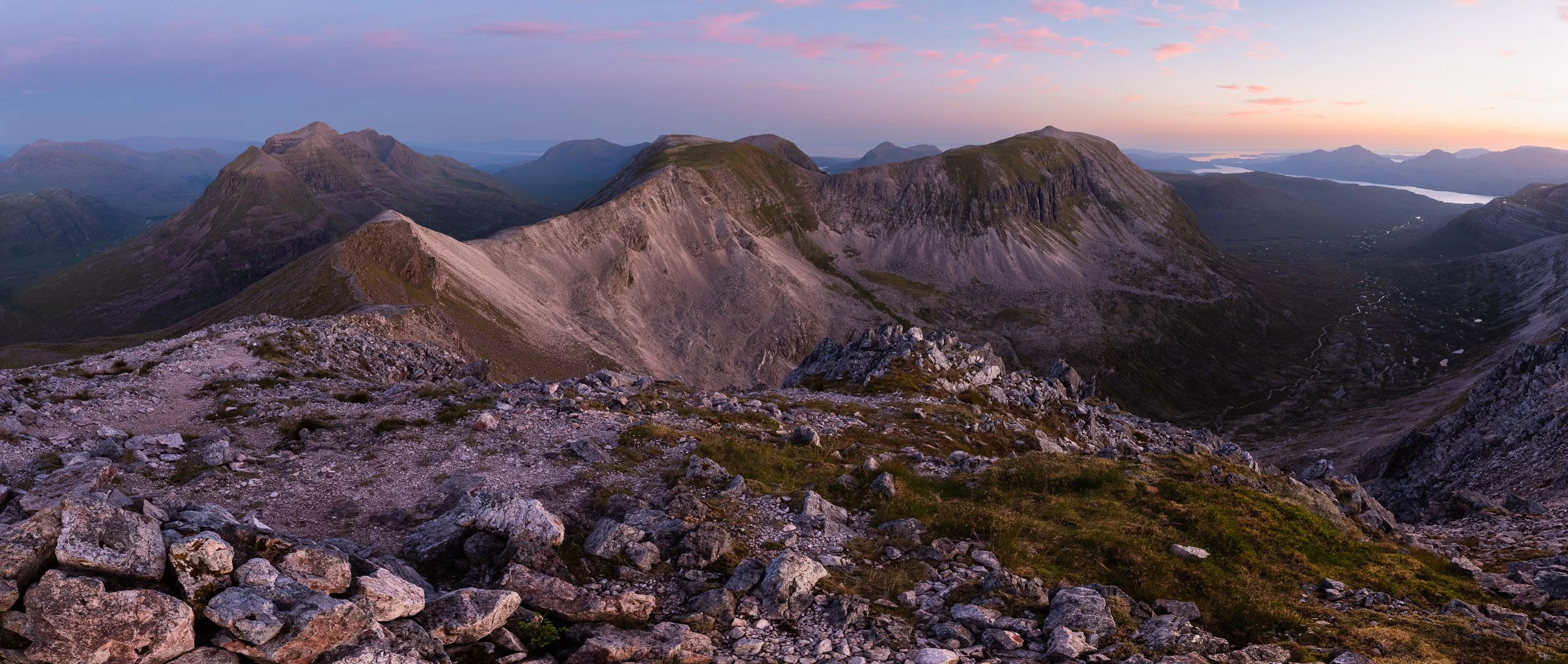 A pink dawn highlights the rocky ridge between Spidean Coire nan Clach on Beinn Eighe towards Coinneach Mhor and Ruadh-stac Mòr in the North-West Highlands of Scotland. Liathach is on the left hand-side. Image © Colin Henderson Photography. Permissio