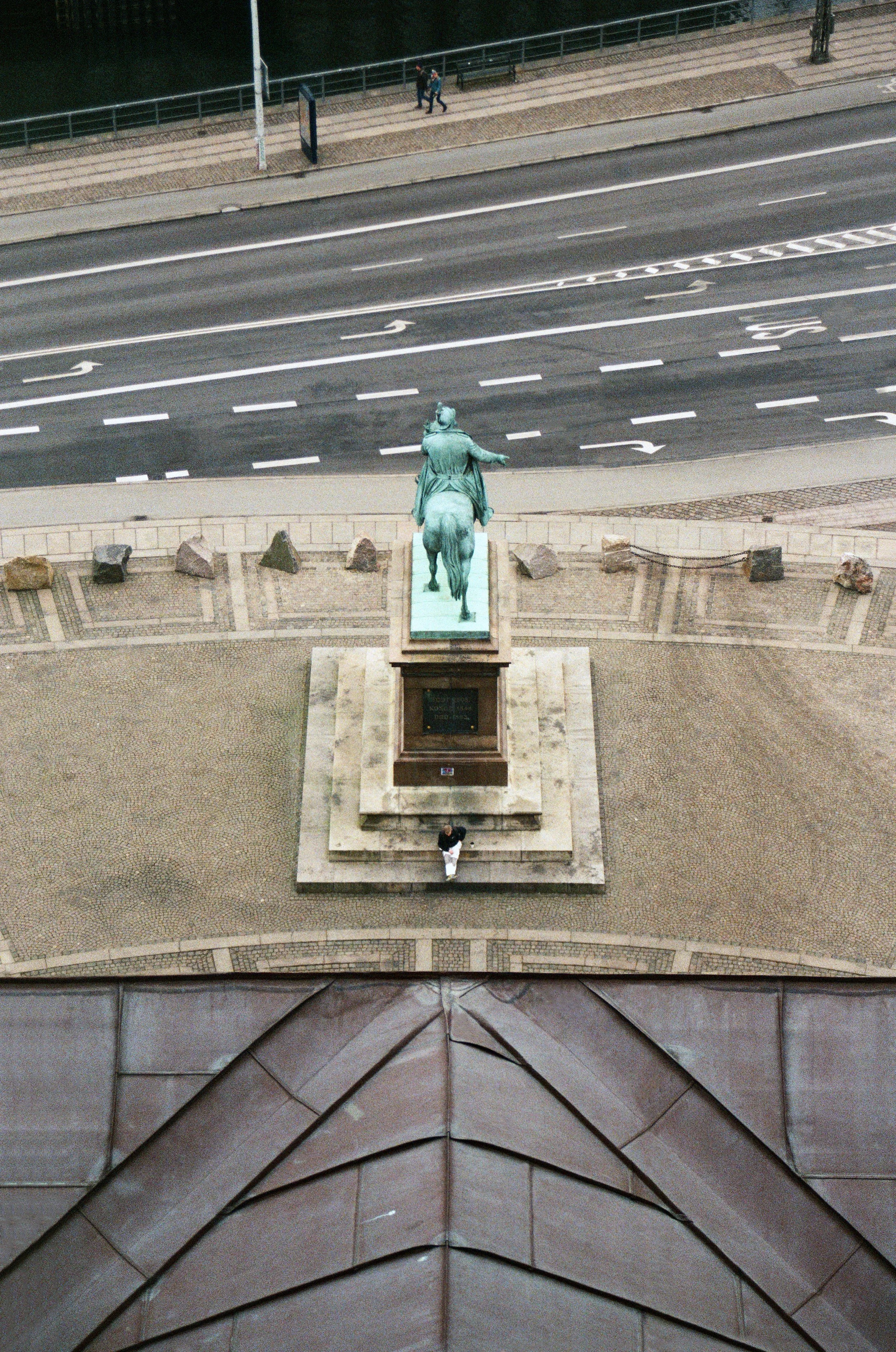 Berlin Statue viewed from above beside a multi-lane road and geometric metal rooftop