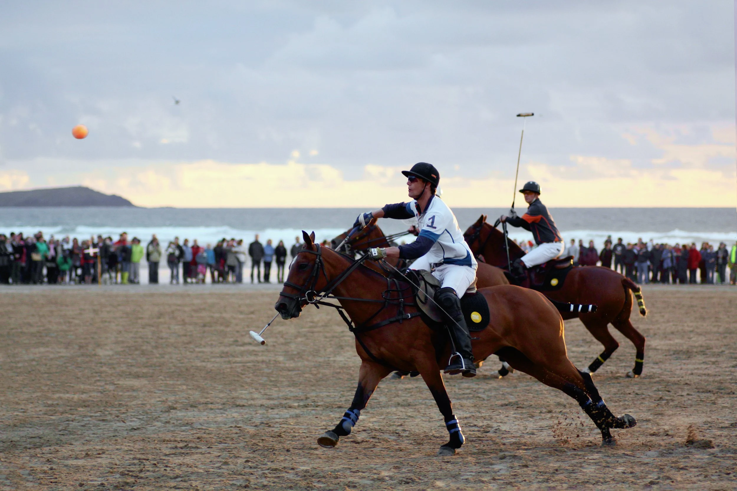 Two polo players riding at speed during a match on Watergate Bay, Cornwall