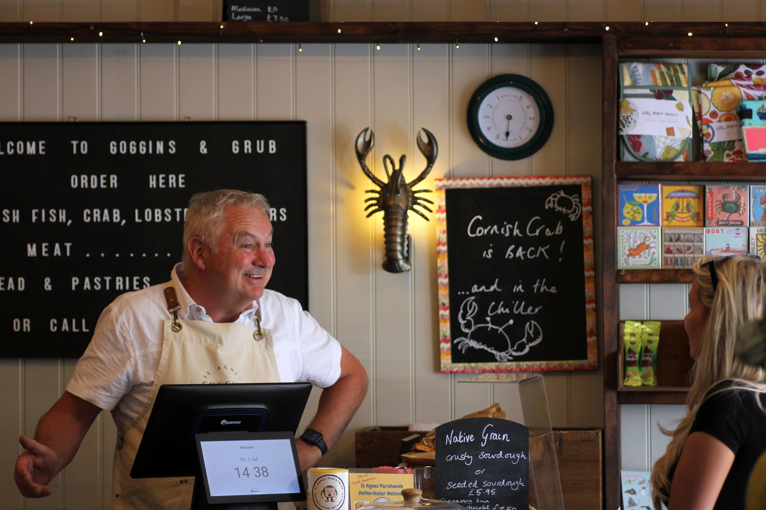 Goggins and Grub Shopkeeper standing behind the counter